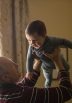 elderly man holding baby in air
